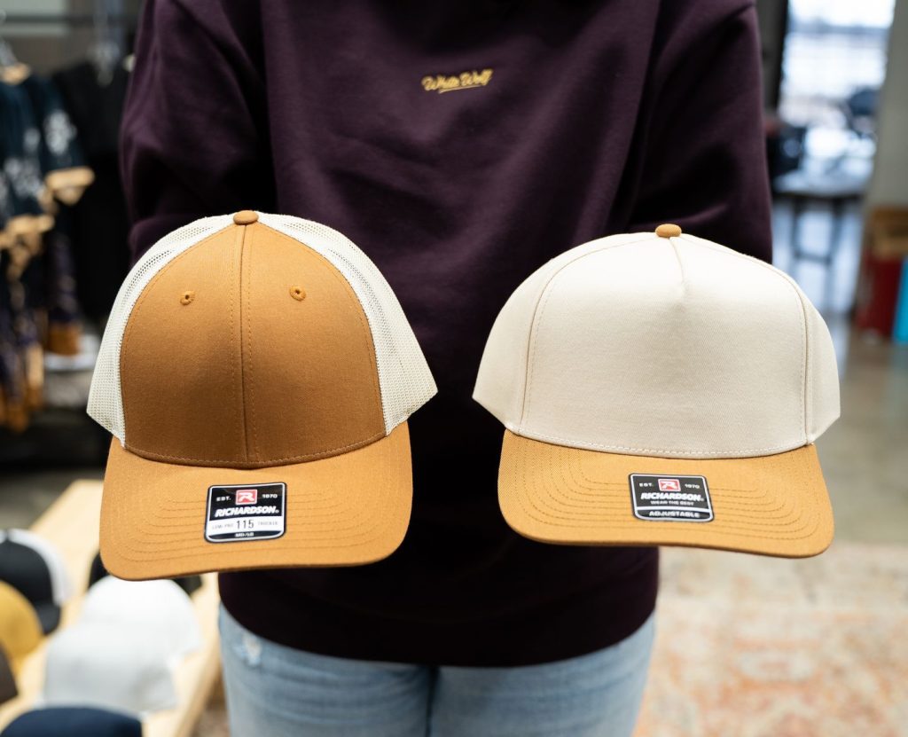 Custom Richardson trucker hats with leather patch branding displayed in a custom apparel shop in Central Minnesota by White Wolf MN.